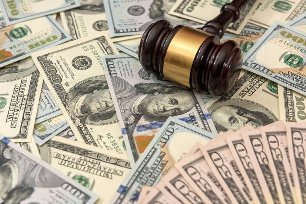 istock wood judge gavel and dollar, 1325901121