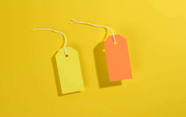 istock blank rectangular paper yellow and orange price tags with white rope on yellow background 1325902092