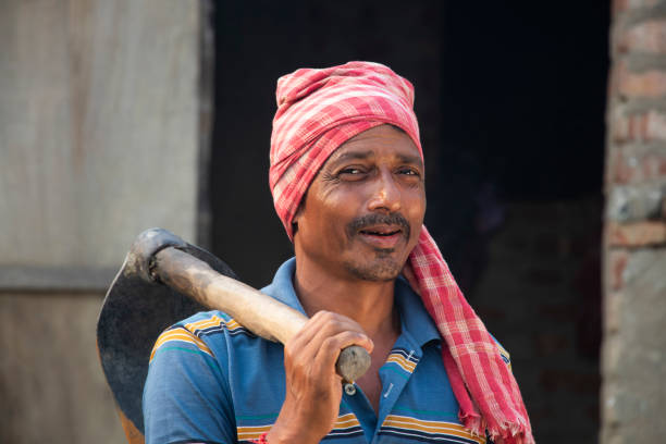 istock Smiling Indian Farmer holding a spade on her shoulder 1325902999