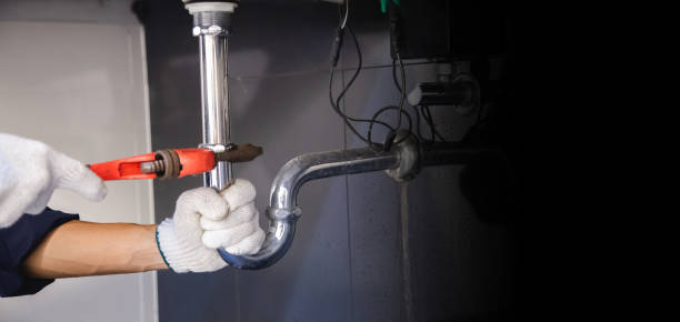 istock Plumber fixing white sink pipe with adjustable wrench. 1325904550