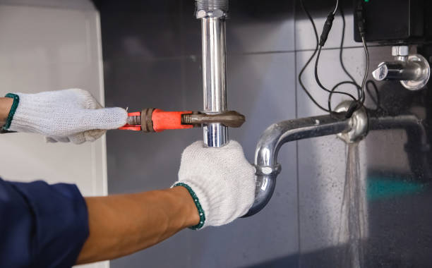 istock Plumber fixing white sink pipe with adjustable wrench. 1325904588