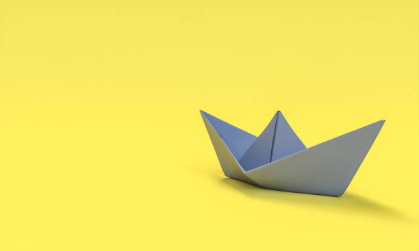 istock gray paper boat on yellow background. 1325904731