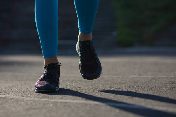 istock Athlete woman feet during jogging workout on the stadium. Empty space 1325905831