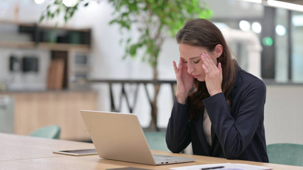 istock Young Businesswoman with Headache using Laptop at Work 1325905853