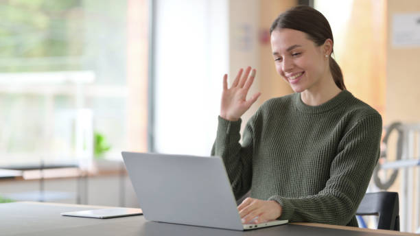 istock Talking Young Woman Doing Video Chat on Laptop 1325906070