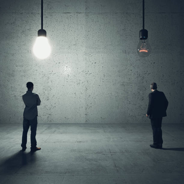 istock men looks at two light bulbs. one is on 1325906712