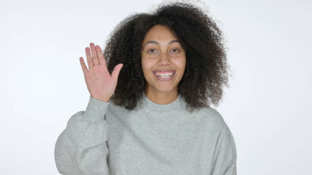 istock Young African Woman Waving Hand for Hello, White Background 1325907482