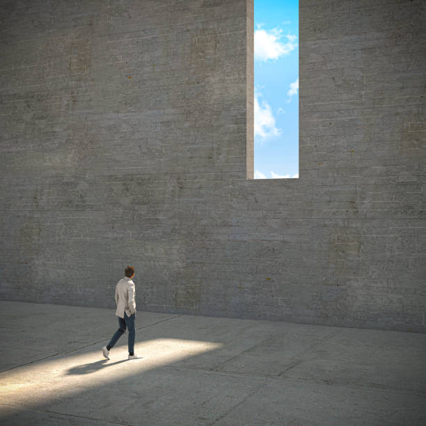 istock man walking towards a window in a concrete wall 1325907490