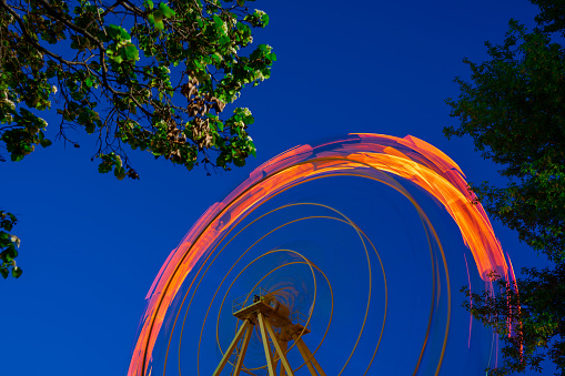 The moving Ferris wheel was photographed at night on a long shutter speed