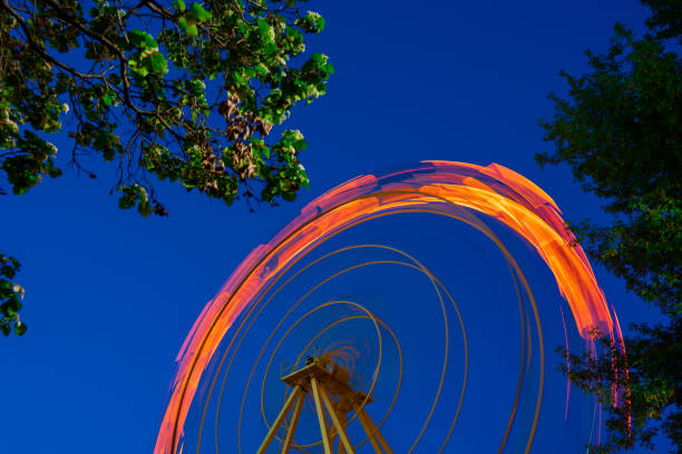 The moving Ferris wheel was photographed at night on a long shutter speed The moving Ferris wheel was photographed at night on a long shutter speed long shutter speed stock pictures, royalty-free photos & images