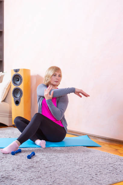 istock Female Training Ideas. Tranquil Mature Female While Exercising On Blue Mat During Session At Home. Vertical Image 1325909767