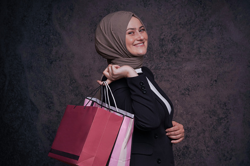 young muslim business woman holding shopping bags