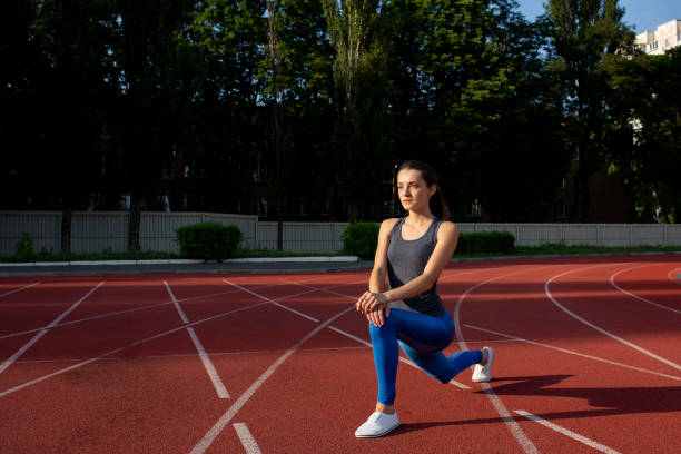 istock Attractive sporty girl stretching before running at the stadium. Empty space 1325911547