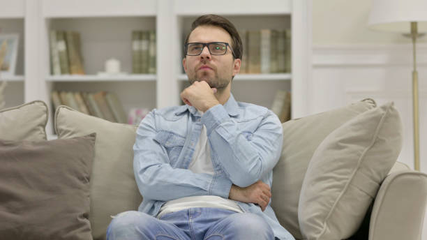 istock Young Man Sitting and Thinking at Home 1325913008