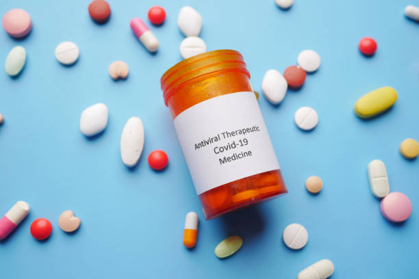 istock covid 19 medical pills spilling on blue background 1325913547