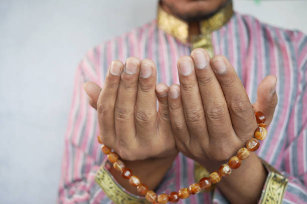 istock muslim man keep hand in praying gestures during ramadan, Close up 1325914417
