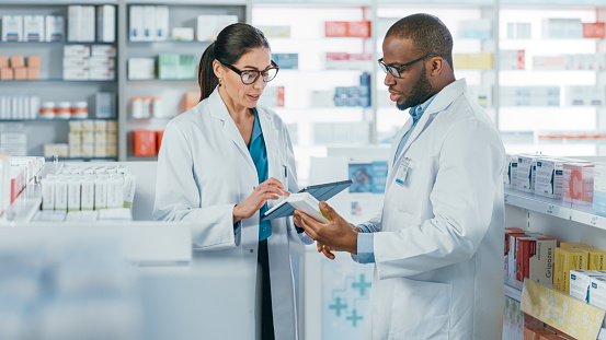 Young pharmacist helping a senior man at the pharmacy