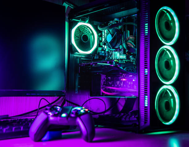 istock Game controller and pc rgb case on a wooden desk 1325918390