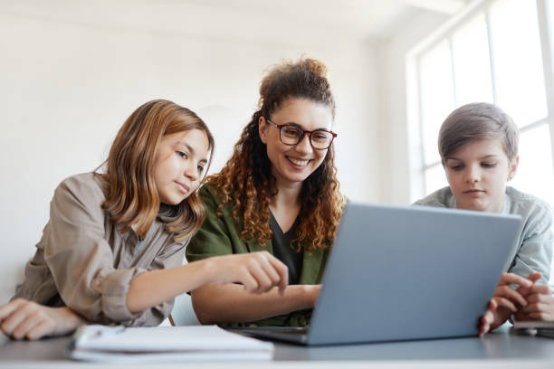istock Smiling Kids with Teacher in Class 1325918658