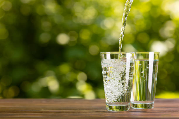 istock water pouring into glass on table outdoors 1325918711