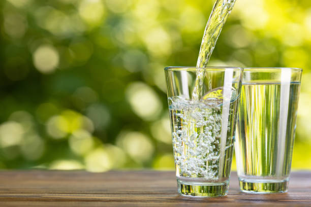 istock water pouring into glass on table outdoors 1325918727
