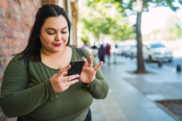 istock Young plus size woman using her mobile phone. 1325922583