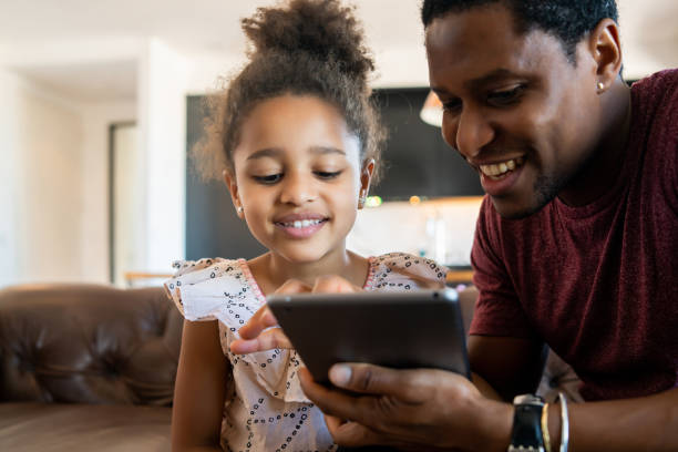 istock Father and daughter using digital tablet at home. 1325922831