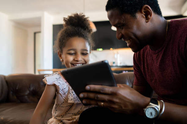 istock Father and daughter using digital tablet at home. 1325922846
