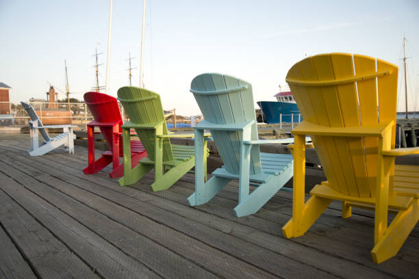 istock Adirondack chairs on a wooden pier. 1325926311