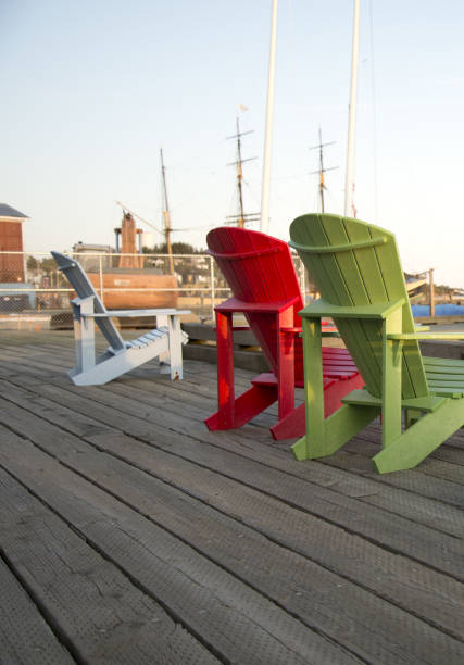istock Adirondack chairs on a wooden pier. 1325926312