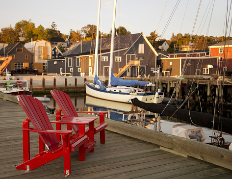 Adirondack chairs on a wooden dock in Lunenburg, Nova Scotia, Canada.