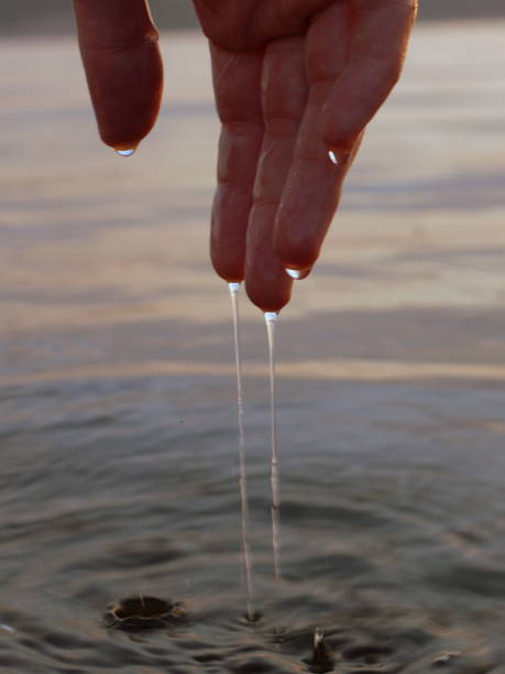 istock Human hand and water droplets 1325929314