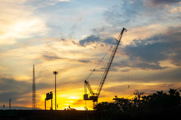 istock Silhouette of construction worker cranes with sunset sky background. 1325931746