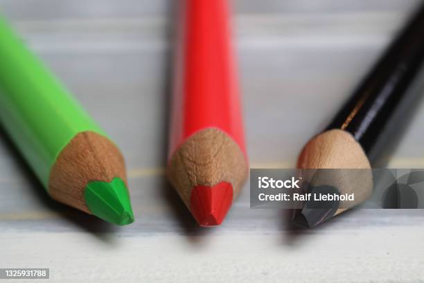 Closeup Of Isolated Colorful Green Red And Black Crayons On Wood Background Stock Photo - Download Image Now
