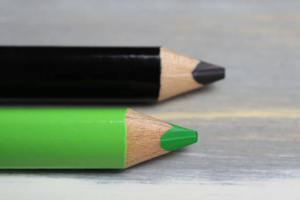 Closeup of isolated colorful black and green crayons on wood background Closeup of isolated colorful black and green crayons on wood background - kiwi coalition concept christian democratic union photos stock pictures, royalty-free photos & images