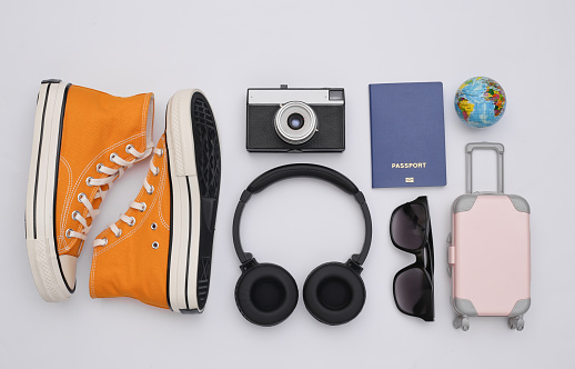 Trafel Flat lay. Stereo headphones, sneakers and travel accessories on white background. Top view