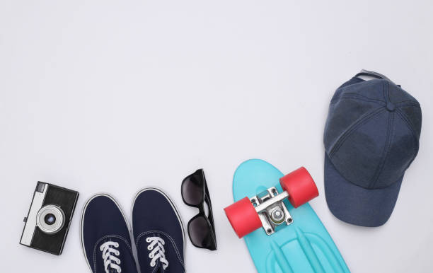 istock Flat lay composition of mini cruiser board, sneakers, cap, sunglasses and camera on white background. Youth, hipster outfit. Copy space. Top view 1325932727