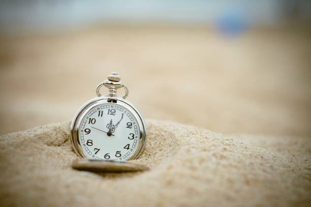 Pocket watch buried in sand