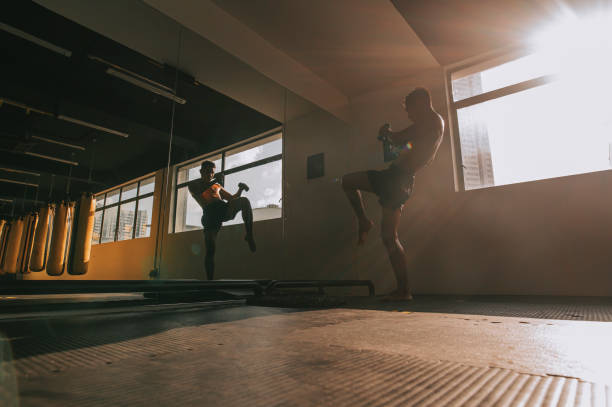 sombra de boxeo asiático muay thai boxeador practicando frente al espejo de perforación de aire - mixed martial arts combative sport boxing kicking fotografías e imágenes de stock
