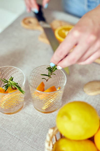 istock Female hand put rosemary in glasses, making fresh lemonade 1325939017