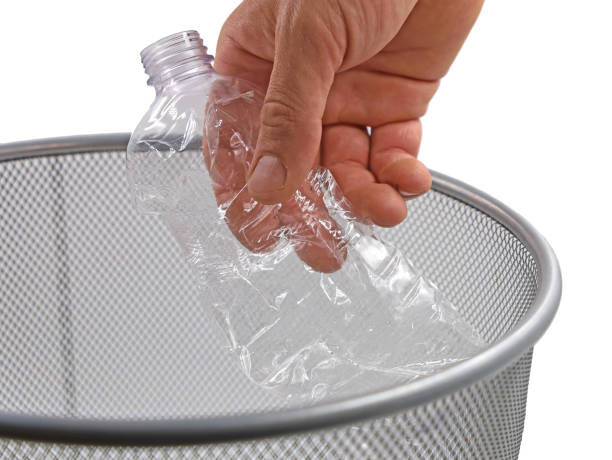 istock close up of hand throwing empty plastic bottle into the trash on white background 1325940644