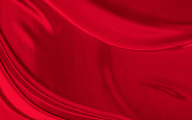 istock Black red satin dark fabric texture luxurious shiny that is abstract silk cloth background with patterns soft waves blur beautiful. 1325944382