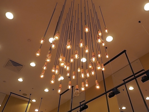 Many glowing bulbs hang from the ceiling. Decorative lighting