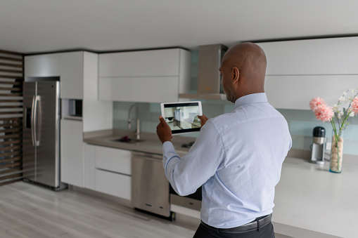 African American Real Estate Agent making a virtual tour of a house for sale or rent using a tablet computer - real estate showing concepts