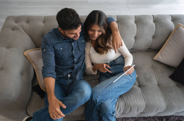 istock Happy couple at home making a video call on a tablet computer 1325947437