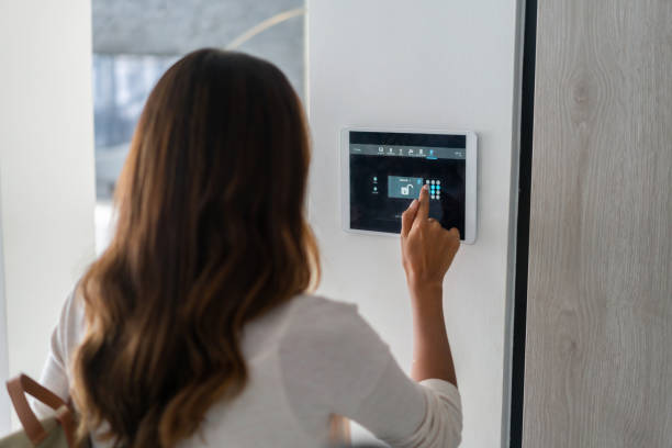 홈 오토메이션 시스템을 사용하여 집 문을 잠그는 여성 - security system security burglar alarm home interior 뉴스 사진 이미지