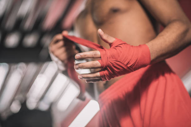istock African american kickboxer typing a bandage on his hand before the workout 1325947628