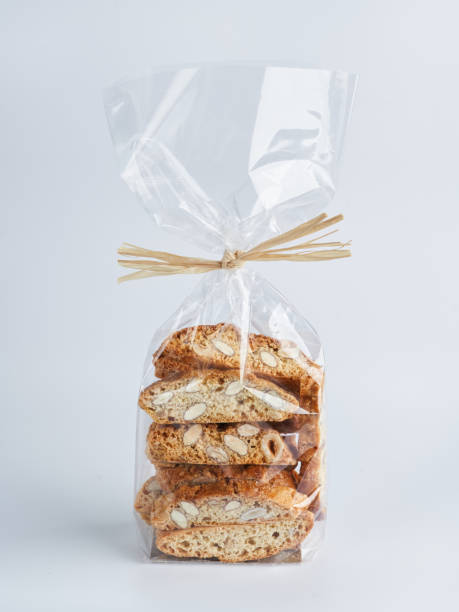 pilha de nozes de amêndoas biscotti cantucci biscoitos biscoitos em embalagens plásticas para venda. biscoitos de sobremesa italianos de perto, foco seletivo, espaço de cópia. conceito de confeitaria de padaria. - biscotti cookie chocolate pistachio - fotografias e filmes do acervo