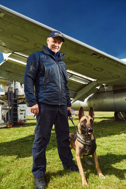 istock Security officer with dog standing near plane at aerodrome 1325948751
