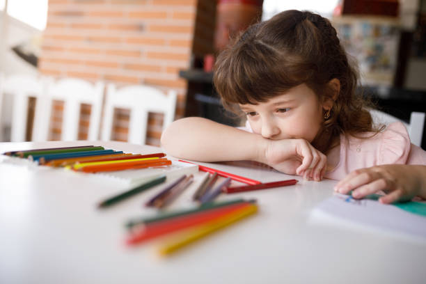 istock Girl looking at colored pencils choosing which one to use 1325949819
